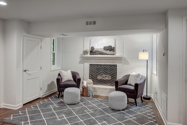 living area with a fireplace and dark wood-type flooring