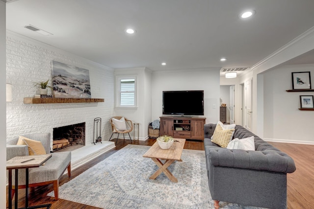 living room with a fireplace, hardwood / wood-style flooring, and ornamental molding