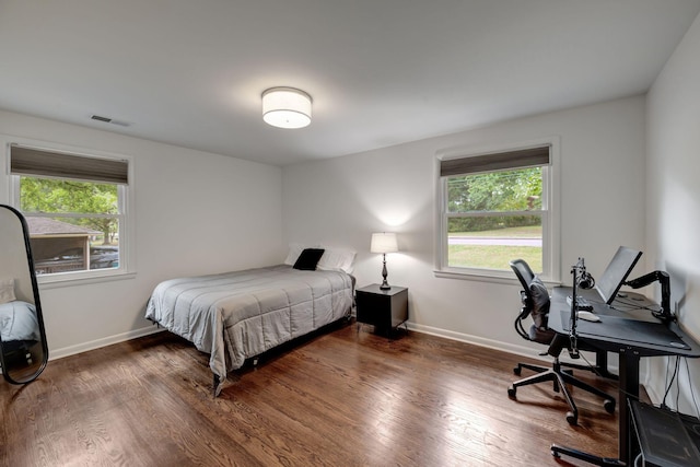 bedroom featuring dark hardwood / wood-style floors and multiple windows