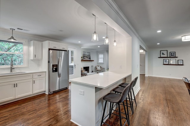 kitchen with a kitchen breakfast bar, white cabinetry, dark hardwood / wood-style flooring, and stainless steel fridge with ice dispenser