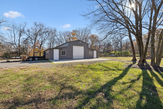 view of property exterior with a garage, an outdoor structure, and a yard