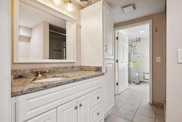 bathroom featuring vanity, electric water heater, and tile patterned floors