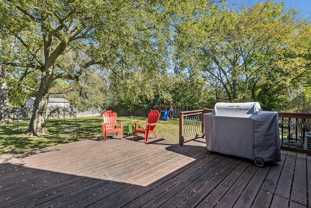 wooden deck featuring a playground, area for grilling, and a lawn