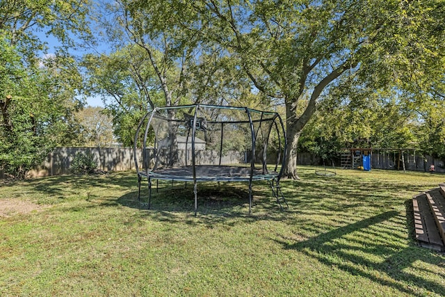 view of yard with a playground and a trampoline