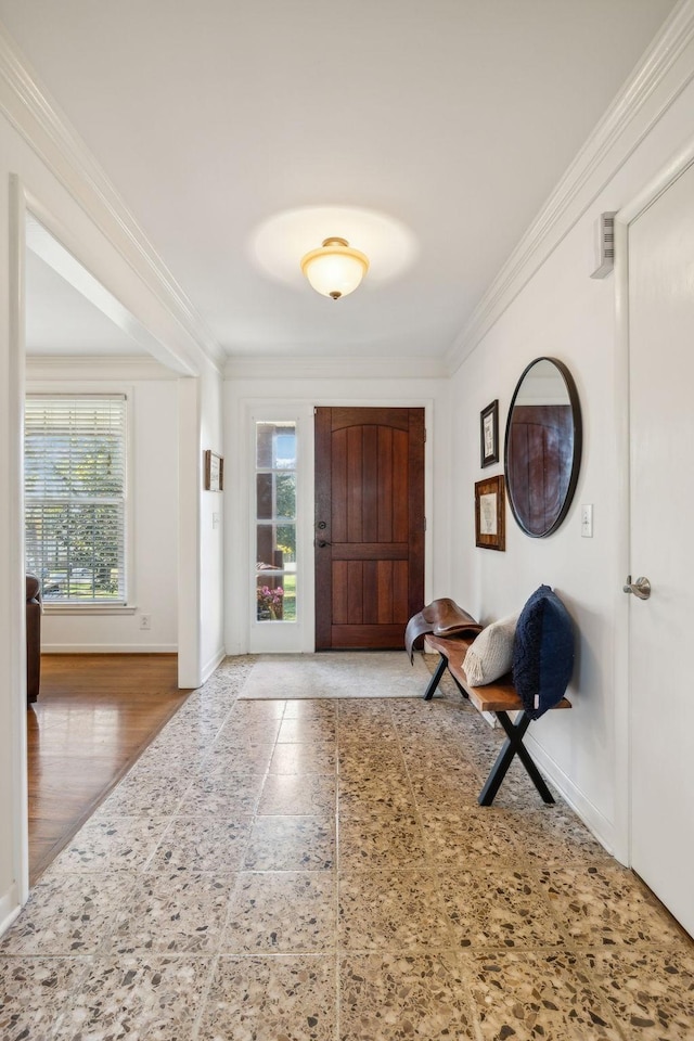 entrance foyer with hardwood / wood-style floors, plenty of natural light, and ornamental molding