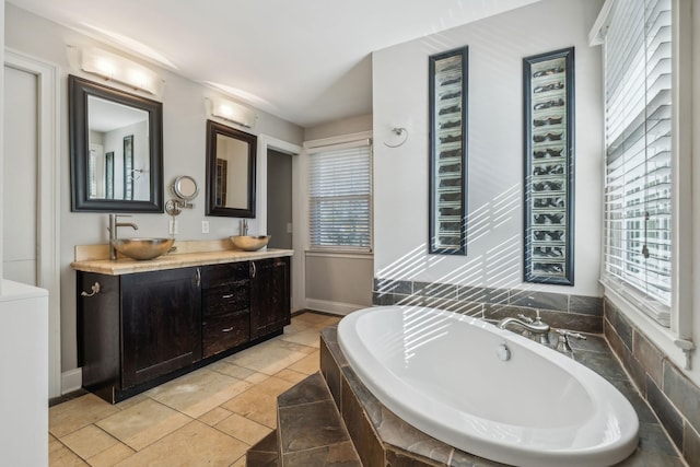 bathroom with vanity, tile patterned floors, and tiled tub