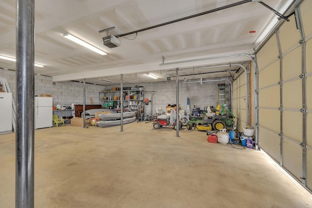 garage with white refrigerator and a garage door opener