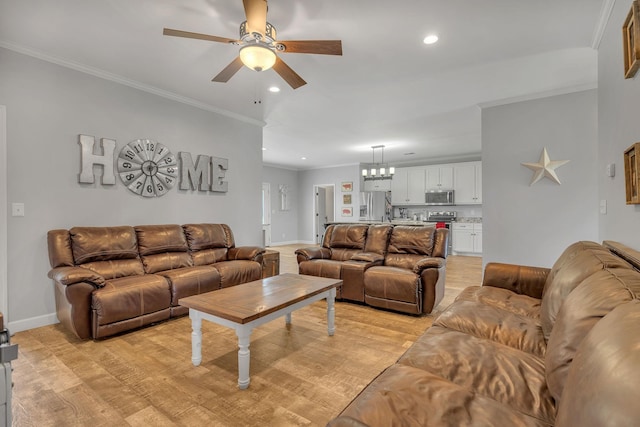 living room with ceiling fan with notable chandelier, light hardwood / wood-style flooring, and ornamental molding