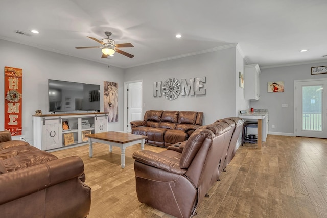 living room featuring ceiling fan, light wood-type flooring, and ornamental molding