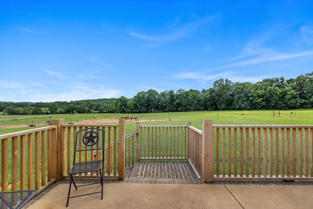 view of gate with a rural view and a lawn