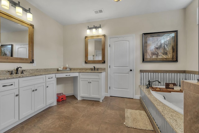 bathroom with vanity and tiled bath