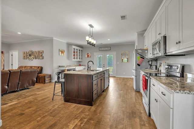 kitchen featuring white cabinets, light hardwood / wood-style floors, sink, and appliances with stainless steel finishes