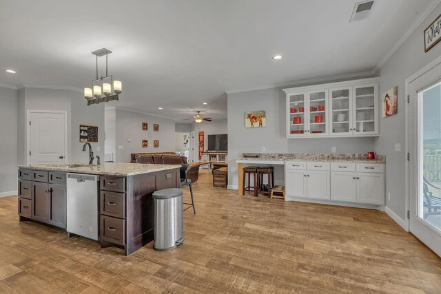 kitchen with white cabinets, stainless steel dishwasher, ceiling fan with notable chandelier, and light hardwood / wood-style floors