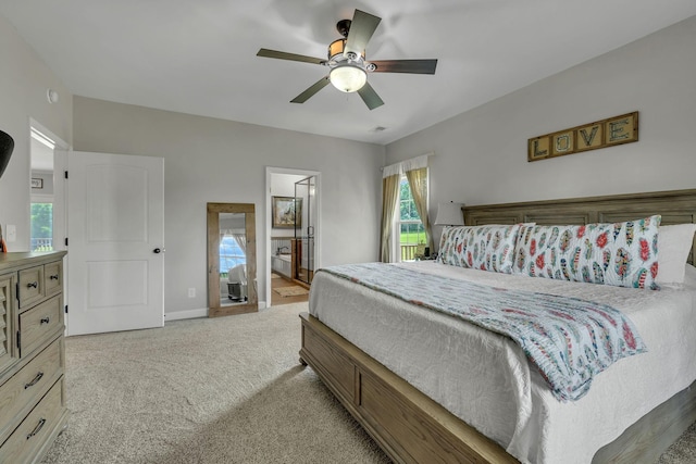 bedroom with light carpet, ensuite bath, and ceiling fan