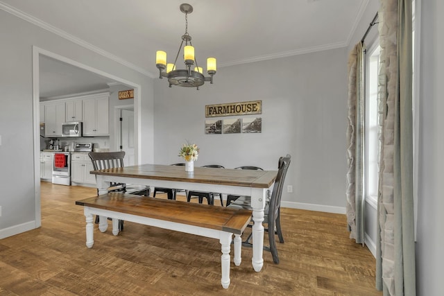 dining room with hardwood / wood-style floors, ornamental molding, and a notable chandelier