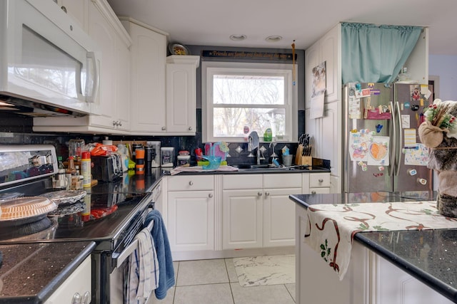 kitchen featuring sink, light tile patterned floors, tasteful backsplash, white cabinetry, and stainless steel appliances