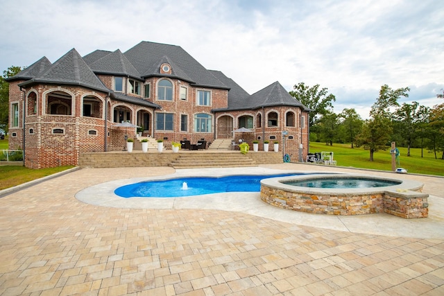 view of swimming pool featuring an in ground hot tub and a patio