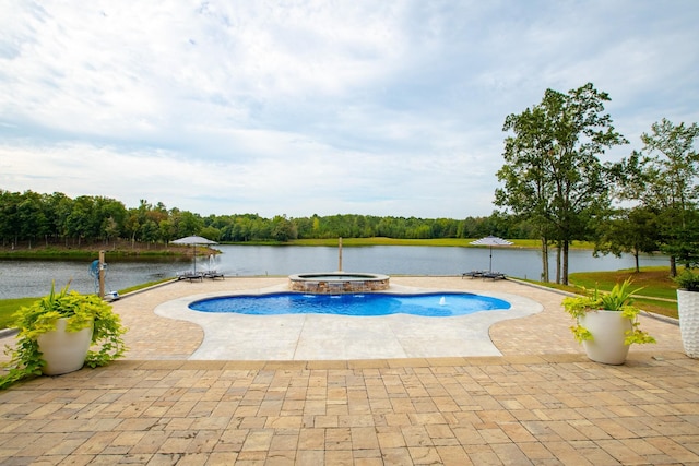 view of swimming pool featuring an in ground hot tub, a water view, and a patio area