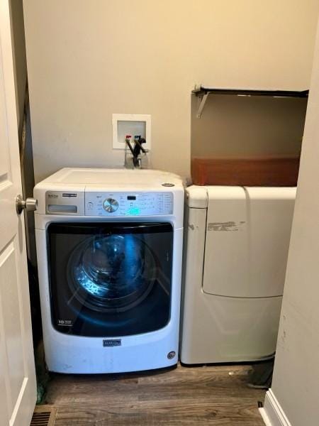 laundry area with separate washer and dryer and dark hardwood / wood-style floors