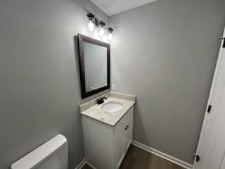 bathroom featuring toilet, vanity, and hardwood / wood-style flooring