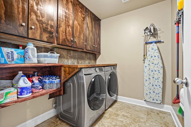 laundry area featuring light tile patterned flooring, cabinets, and washing machine and clothes dryer