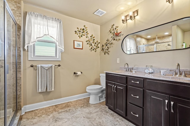 bathroom with vanity, toilet, and a shower with door