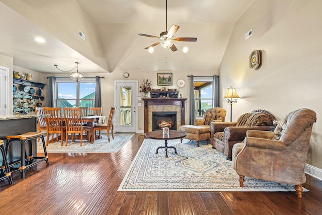 living room with ceiling fan with notable chandelier, a wealth of natural light, and dark wood-type flooring