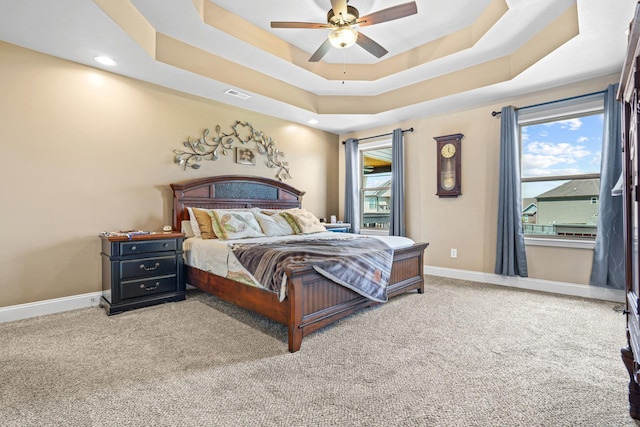 bedroom featuring carpet flooring, a raised ceiling, and ceiling fan