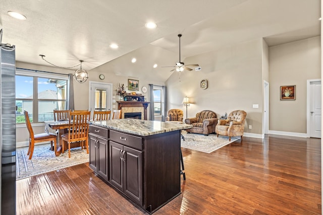 kitchen with dark brown cabinets, a center island, a water view, and dark hardwood / wood-style floors