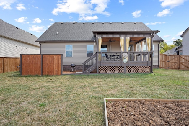 rear view of house with ceiling fan, a yard, and a wooden deck