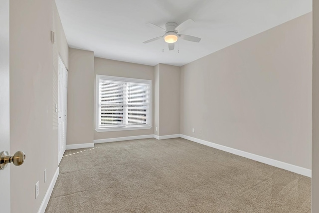 carpeted empty room featuring ceiling fan