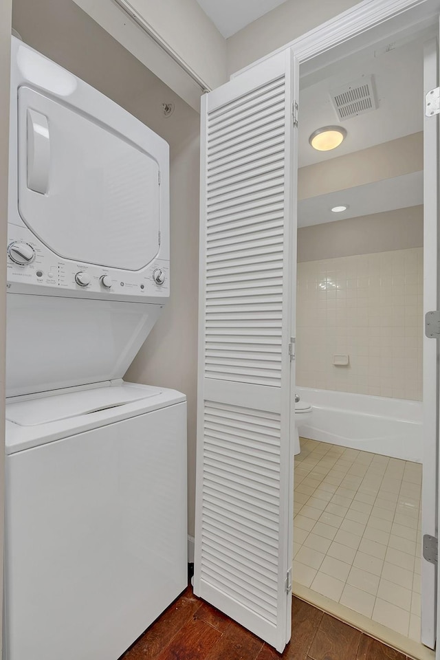 washroom featuring stacked washer and clothes dryer