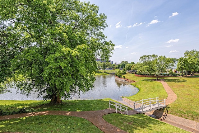 view of property's community with a lawn and a water view