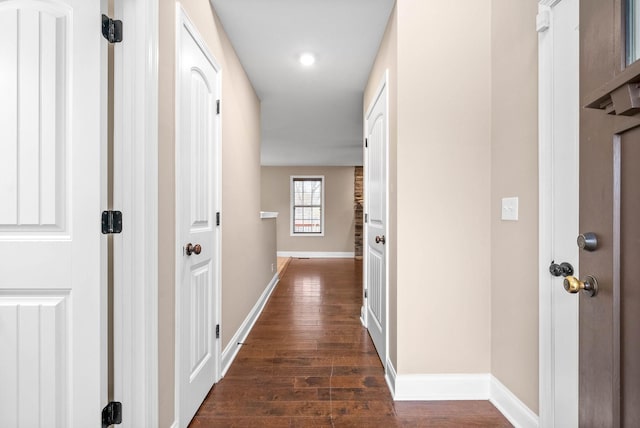 corridor with dark hardwood / wood-style flooring