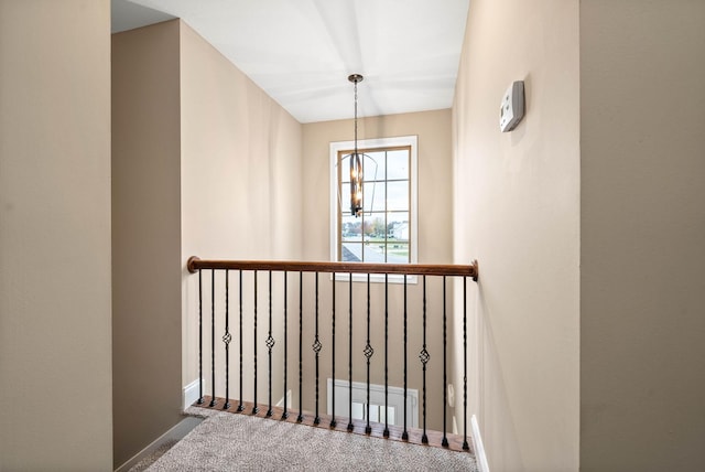 stairs featuring carpet floors and a notable chandelier