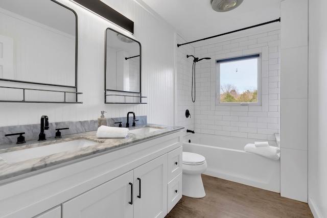 full bathroom with vanity, toilet, wood-type flooring, and tiled shower / bath