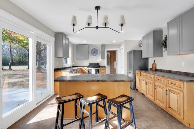 kitchen with appliances with stainless steel finishes, gray cabinets, light tile patterned floors, and a notable chandelier