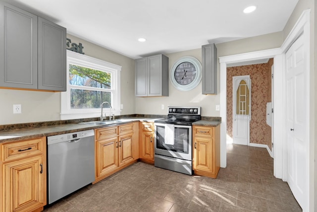 kitchen with gray cabinets, dark tile patterned floors, sink, and appliances with stainless steel finishes