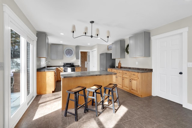 kitchen with a center island, an inviting chandelier, sink, a breakfast bar area, and stainless steel appliances