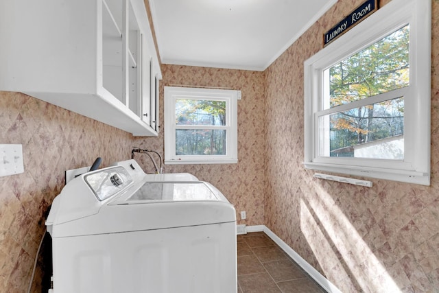 laundry room featuring washer and clothes dryer, cabinets, crown molding, and a wealth of natural light