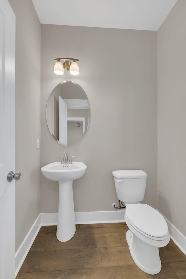 bathroom with toilet and wood-type flooring