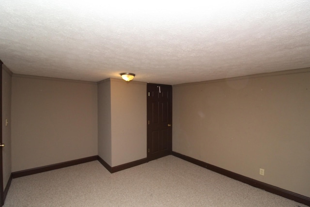 spare room with a textured ceiling and light colored carpet