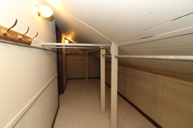 walk in closet featuring light carpet and vaulted ceiling