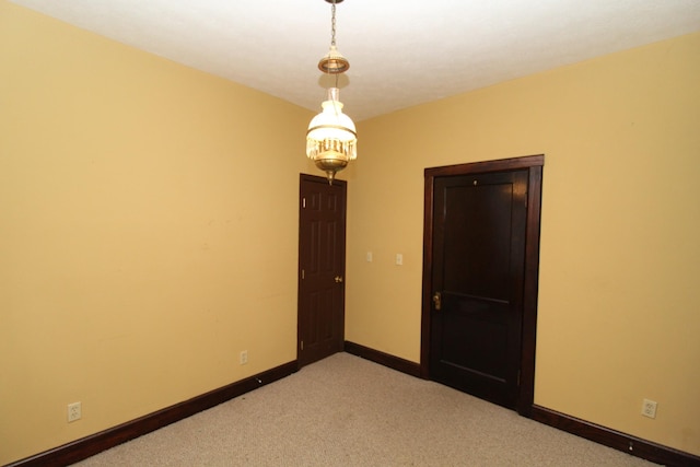 unfurnished room with a chandelier and light colored carpet