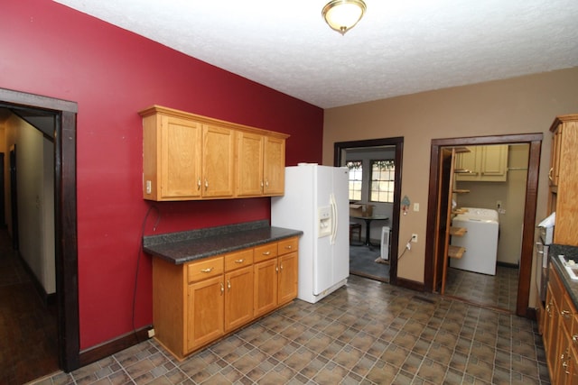 kitchen featuring washer / dryer, a textured ceiling, and white fridge with ice dispenser