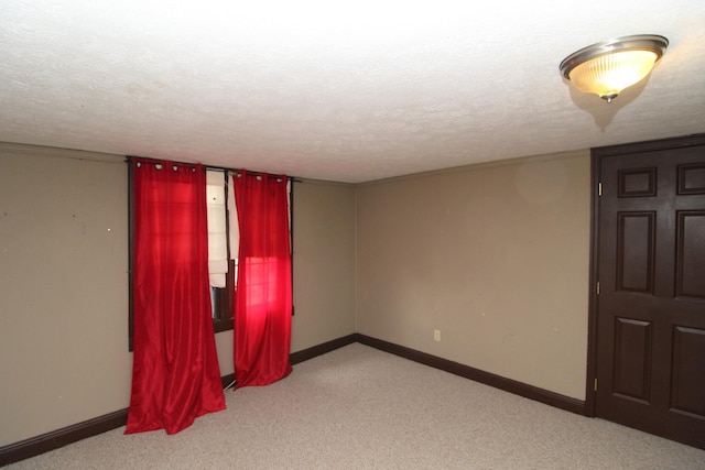 carpeted spare room featuring a textured ceiling