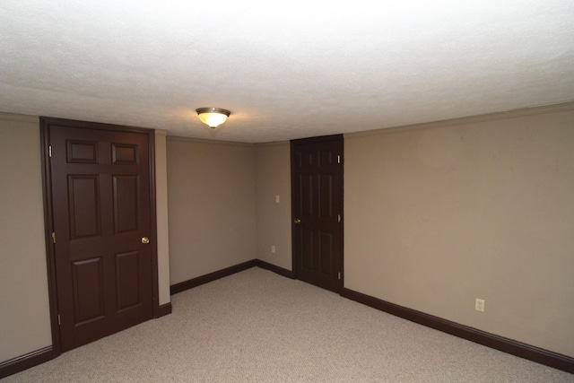 unfurnished room featuring a textured ceiling and light carpet