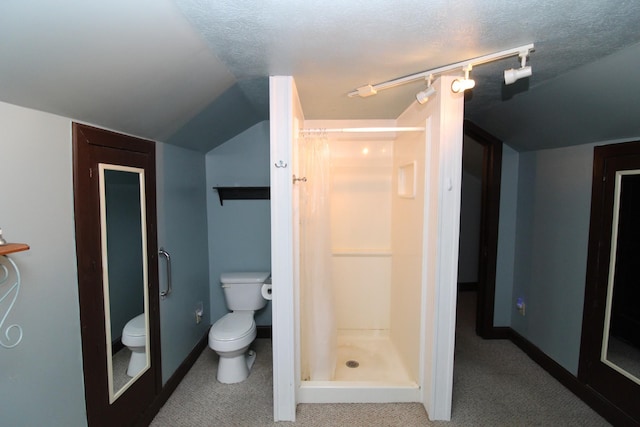 bathroom featuring a textured ceiling, toilet, walk in shower, and lofted ceiling