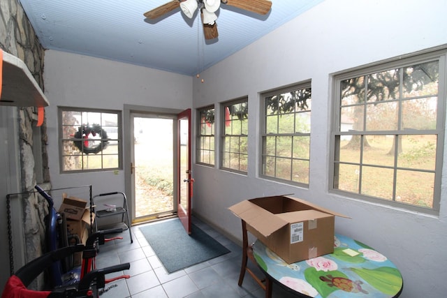 sunroom featuring ceiling fan, a healthy amount of sunlight, and lofted ceiling