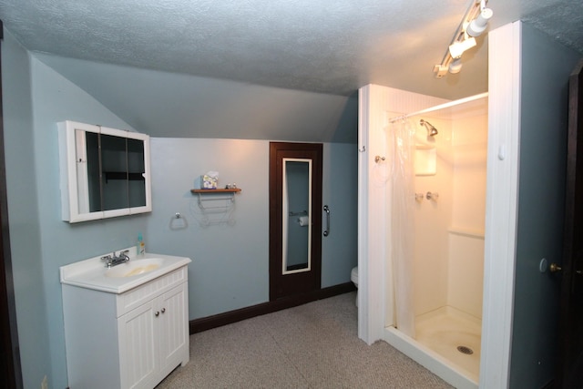 bathroom with vanity, a shower, lofted ceiling, and a textured ceiling